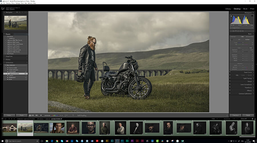 A man and his motorcycle are standing on the grass.